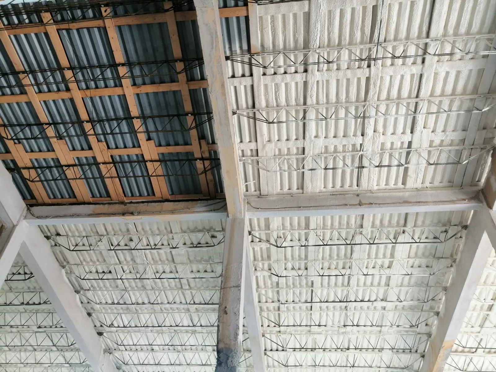 Acoperișul unei hale cu structură din lemn și metal, izolat cu spumă aplicată pe tablă